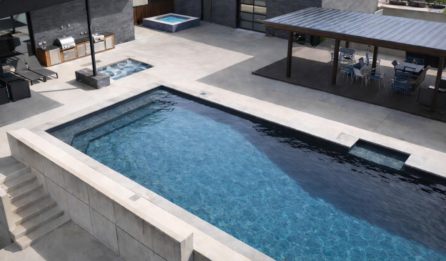 Aerial view of modern ICF pool with Renolit PVC membrane, dark interior, hot tub and shaded patio area
