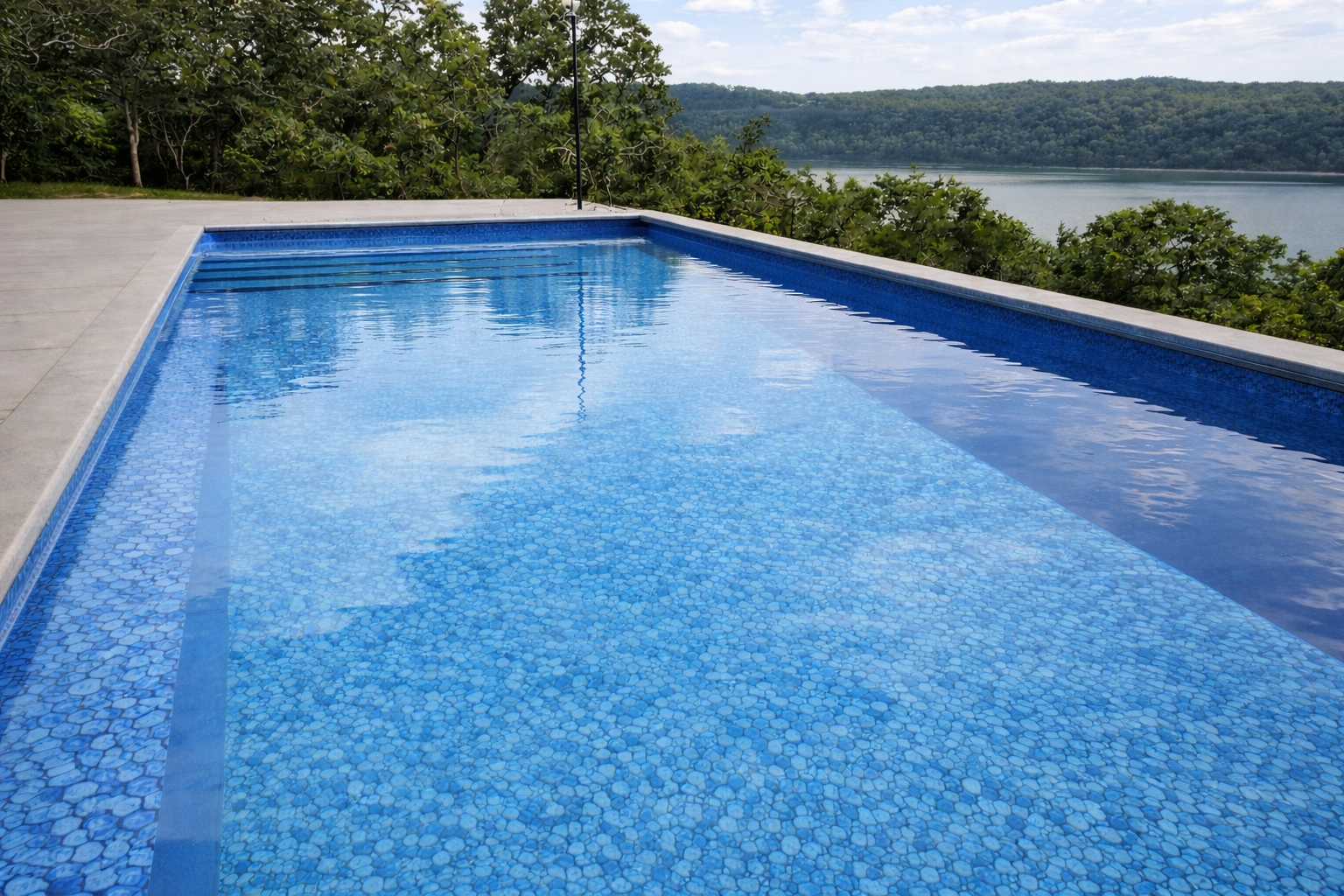 Rectangular ICF pool with blue pebble vinyl liner finish, lake and forest backdrop